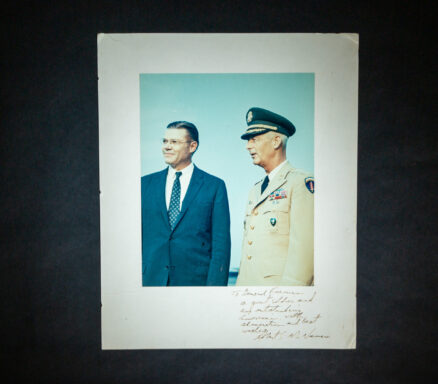 Photograph of Secretary of Defense Robert S. McNamara with Army General Paul L. Freeman, Jr., signed on the mount by McNamara with inscription.