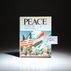 First edition of Peace, a photographic history of the Camp David Accords, with text by Anthony S. Pitch and a preface by Chaim Herzog. Signed by President Jimmy Carter on the half-title.