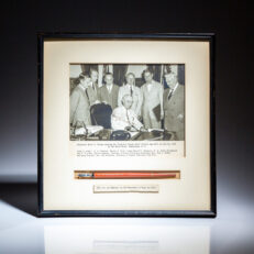 Signed photograph of President Harry S. Truman signing the "Judicial Salary Bill" on July 31, 1946, with the pen used to sign the bill mounted below photograph. From the estate of Assistant Attorney General H. Graham Morison.