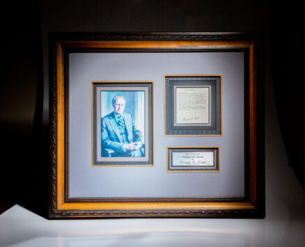 Signed copy of President Gerald R. Ford's pardon of Richard Nixon, framed with color photograph of Ford.