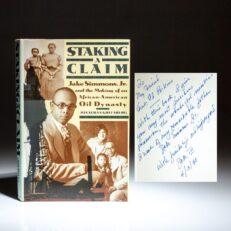 First edition of Staking a Claim by Jonathan D. Greenberg, inscribed by Jake Simmons III to U.S. Ambassador Ed Perkins.