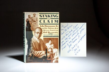 First edition of Staking a Claim by Jonathan D. Greenberg, inscribed by Jake Simmons III to U.S. Ambassador Ed Perkins.