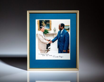 Signed photograph of President Ronald Reagan and the United States Ambassador to South Africa, Edward J. Perkins. Signature of Ronald Reagan is autopen.