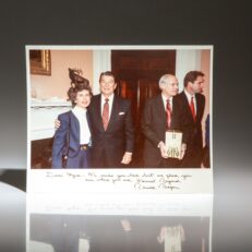 Signed photograph of President Ronald Reagan and Myra L. Tankersley at the reception for outgoing Attorney General William French Smith held in the Roosevelt Room of the White House on February 22, 1985.