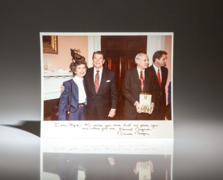 Signed photograph of President Ronald Reagan and Myra L. Tankersley at the reception for outgoing Attorney General William French Smith held in the Roosevelt Room of the White House on February 22, 1985.